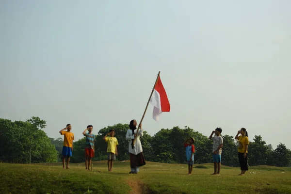 Endonezya 'nın 78. bağımsızlık günü olan 17 Ağustos 2023, 6 Ağustos 2023 tarihli Endonezya ulusal bayrağına saygı gösteren çocuklar.