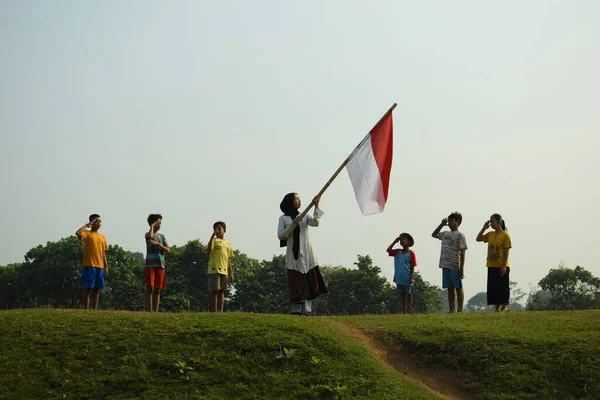 Endonezya 'nın 78. bağımsızlık günü olan 17 Ağustos 2023, 6 Ağustos 2023 tarihli Endonezya ulusal bayrağına saygı gösteren çocuklar.