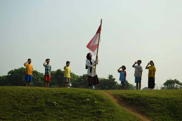 Endonezya 'nın 78. bağımsızlık günü olan 17 Ağustos 2023, 6 Ağustos 2023 tarihli Endonezya ulusal bayrağına saygı gösteren çocuklar.