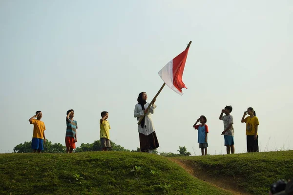 Endonezya 'nın 78. bağımsızlık günü olan 17 Ağustos 2023, 6 Ağustos 2023 tarihli Endonezya ulusal bayrağına saygı gösteren çocuklar.