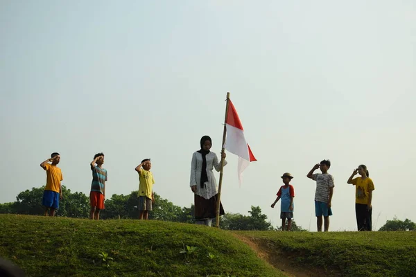 Endonezya 'nın 78. bağımsızlık günü olan 17 Ağustos 2023, 6 Ağustos 2023 tarihli Endonezya ulusal bayrağına saygı gösteren çocuklar.