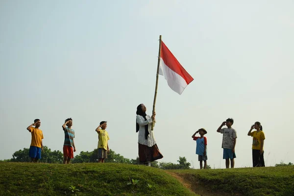 Endonezya 'nın 78. bağımsızlık günü olan 17 Ağustos 2023, 6 Ağustos 2023 tarihli Endonezya ulusal bayrağına saygı gösteren çocuklar.