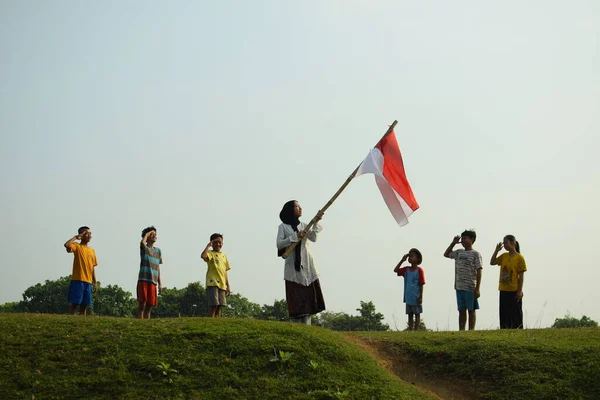 Endonezya 'nın 78. bağımsızlık günü olan 17 Ağustos 2023, 6 Ağustos 2023 tarihli Endonezya ulusal bayrağına saygı gösteren çocuklar.