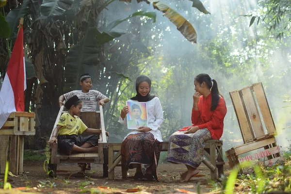 Sanki bir anne ve baba çocuklarına kahraman kıyafeti giyen bir kahraman hakkında bir hikaye anlatıyor. Bu fotoğraf 17 Ağustos 1945 'te Endonezya Bağımsızlık Günü anısına çekildi. Tangerang, 06 Ağustos 2023.