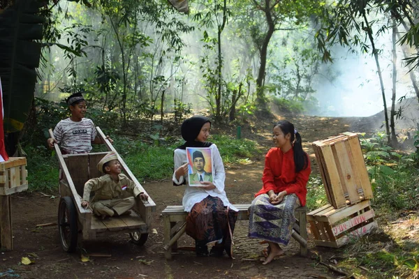 Sanki bir anne ve baba çocuklarına kahraman kıyafeti giyen bir kahraman hakkında bir hikaye anlatıyor. Bu fotoğraf 17 Ağustos 1945 'te Endonezya Bağımsızlık Günü anısına çekildi. Tangerang, 06 Ağustos 2023.