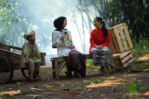 Sanki bir anne ve baba çocuklarına kahraman kıyafeti giyen bir kahraman hakkında bir hikaye anlatıyor. Bu fotoğraf 17 Ağustos 1945 'te Endonezya Bağımsızlık Günü anısına çekildi. Tangerang, 06 Ağustos 2023.