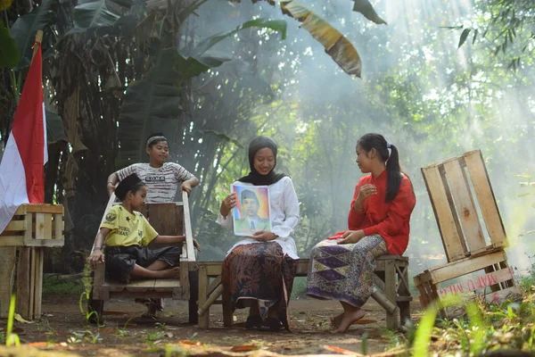 Sanki bir anne ve baba çocuklarına kahraman kıyafeti giyen bir kahraman hakkında bir hikaye anlatıyor. Bu fotoğraf 17 Ağustos 1945 'te Endonezya Bağımsızlık Günü anısına çekildi. Tangerang, 06 Ağustos 2023.