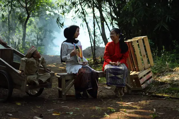 Sanki bir anne ve baba çocuklarına kahraman kıyafeti giyen bir kahraman hakkında bir hikaye anlatıyor. Bu fotoğraf 17 Ağustos 1945 'te Endonezya Bağımsızlık Günü anısına çekildi. Tangerang, 06 Ağustos 2023.