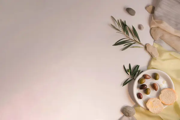 Asgari ve yaratıcı zeytin dalı konsepti, olgun zeytinli bir tabak ve ekmek brunch 'ı. Beyaz arkaplanda Akdeniz sebze gastrosu teması ve boşluk.