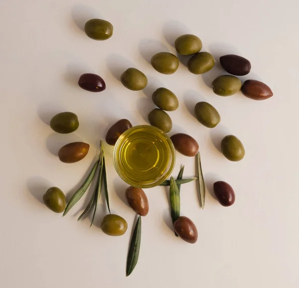 Beyaz arka planda basit doğal bileşim zeytin, ekstra saf zeytin yağı ve zeytin ağacı yaprakları da dahil.. 