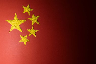 Kırmızı zemin üzerinde pirinçten yapılmış sarı yıldızlı Çin bayrağı..