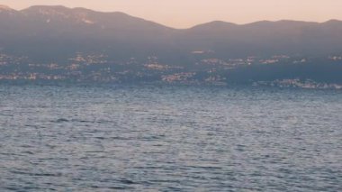 Sabah denizi manzaralı güzel bir deniz manzarası ve arka planda küçük köyleri olan dağlar. 4k video görüntüsü.