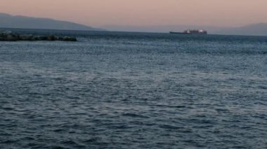 Rijeka limanında deniz manzarasını gösteren 4k yavaş çekim videosu güzel bir deniz manzarası gösteriyor. Arka planda görünür dalgakıranlar, ticaret gemileri ve adalar.