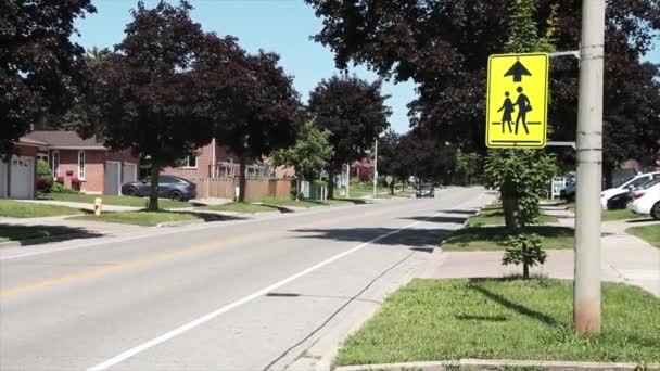 宽的霓虹灯黄色校区标志黑色向上箭头旁边的长住宅街与车辆通过的背景 — 图库视频影像