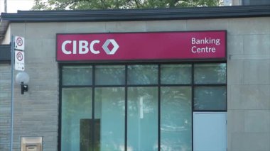 Cibc Kanada İmparatorluk Ticaret Bankası logosu, bankacılık merkezi başlığı ve pencereleri olan bir banka. Önden geçen trafik işareti yok.