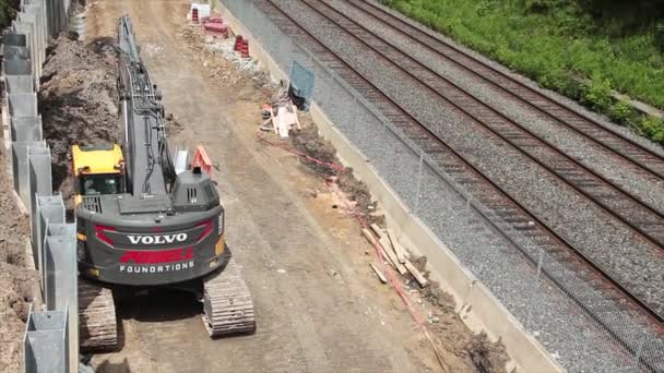 Stavební Zařízení Volvo Vedle Kolejí Vlaku Vystřelené Zezadu Sklopnou Skořepinou — Stock video