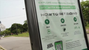 Toronto, arka planda motorsikletli bisikletçinin geçişi ile ilgili talimatları içeren bir e-bisiklet reklam panosu kiraladı.