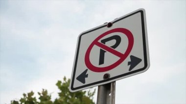 Her iki yönde de park yeri yok. Metal direkte siyah ve kırmızı iz, çerçeve sağ arka planda gökyüzü ve ağaç, sağdan sola kayma hareketi olan beyaz kare işareti yok.