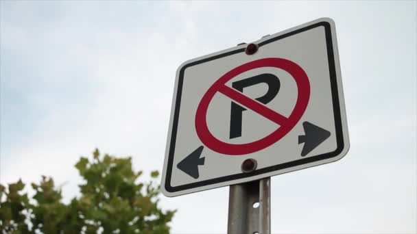 禁止停车标志白色正方形标志 铁柱上有黑字和红字 车架右 天空和树木为背景 — 图库视频影像