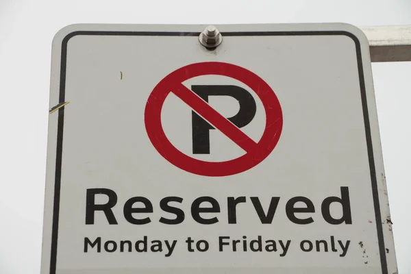 没有预订星期一至星期五的停车场 只以黑色字体在白色背景上签名 后面有天空 大写字母P 红色圆圈横过 — 图库照片
