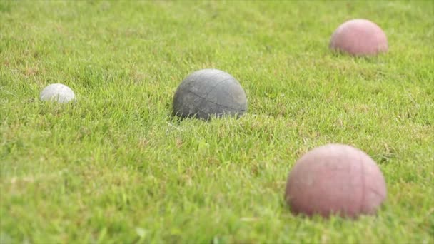 イタリアのゲームボケ 古い着用ボールのセット つの緑とショット スクリーンの右の赤 白いボール スクリーン左 前景のぼやけた草で低角度から撮影 — ストック動画