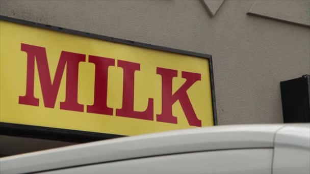 Sarı Yatay Tabela Üzerinde Kırmızı Büyük Harfli Süt Yazıyor Önplanda — Stok video