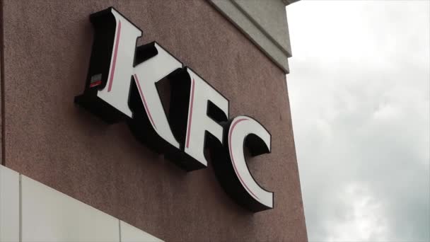 Kfc ケンタッキー フライドチキンロゴ バックグラウンドで空にアングルショットストアの正面玄関 — ストック動画