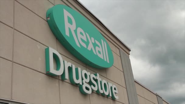 Logo Farmacia Rexall Entrada Frontal Tienda Escritura Blanca Azul Ovalado — Vídeo de stock