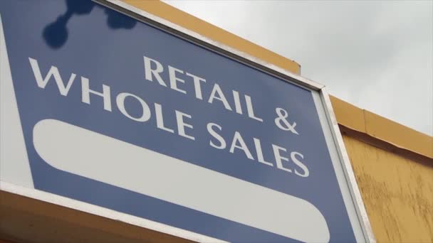 零售和整个销售标题在商店建筑上用大写字母写上文字签名 白字写上蓝色背景 底部有长长的白色椭圆形 — 图库视频影像