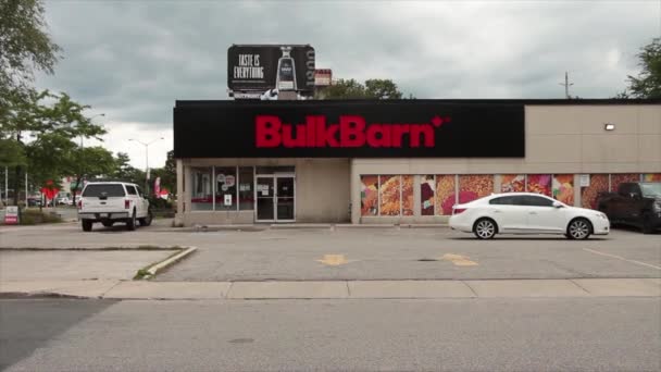 Bulk Barn Store Entrance Wide Shot White Car Leaving Parking — Stock Video