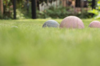 İtalyan oyun bocce, eski yıpranmış toplar bir yeşil ve iki kırmızı ekran ile sol beyaz top ekran, düşük açılı ön planda bulanık çimen ile çekim