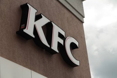 Mağazanın girişinde kFC Kentucky kızarmış tavuk logosu. Arka planda gökyüzü olan açıyla çekilmiş.