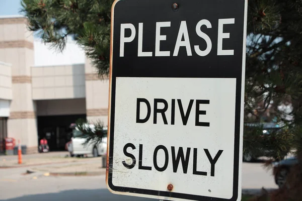 请您慢慢地驾驶 并在后面跟着写上带有停车场的矩形金属标志 写上黑白相间的大写字母 — 图库照片