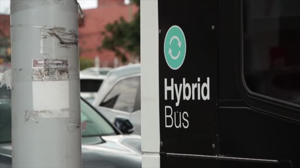 Hybrid Bus Writing Text Caption Words Printed Bus Stopped Light — Stock Video