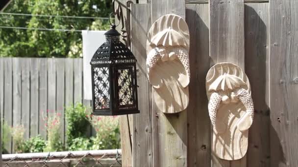 Two Beige Sandal Decorative Ornaments Hanging Wooden Wood Colored Fence — Stock Video