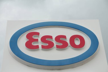 Espso benzin istasyonunun logosu en üst fiyat tabelasında, mavi oval içinde kırmızı, beyaz arka planda ve arkasında gökyüzü yazılı.