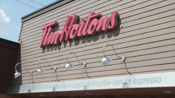 Tim Hortons咖啡店前面的Tim Hortons标志写着Espresso Bagels Latte Donuts Coffee Muffins Cappuccino 红色标志 — 图库视频影像