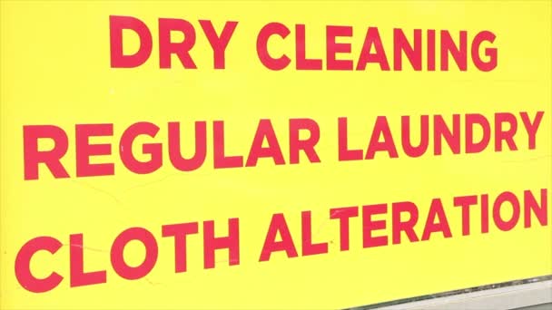 ドライクリーニング 黄色い背景の赤いキャピタル文字で定期的な洗濯布の変更ライティングキャプションテキストサイン — ストック動画