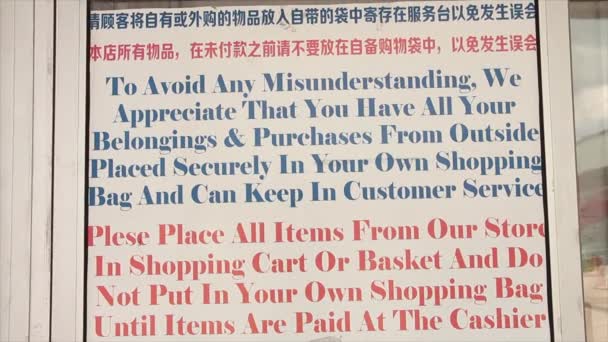 长杂货店说明标志 以防止商店偷窃张贴在门口 顾客进入自动门在右边 英汉书写 蓝色红白 — 图库视频影像