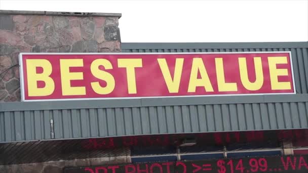 最高の値ワードキャプションテキスト横の長方形のサイン 赤い背景に黄色の店頭に背後にある空とサイン — ストック動画