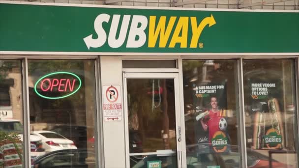 地铁三明治店前入口 上面有标志 车窗倒影 霓虹灯开放标志和橱窗上的海报 — 图库视频影像