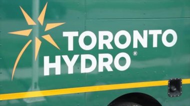 Toronto hidro logo tarafı olan iş kamyonu, yeşil sarı beyaz ve lastik, yansıma tarafından geçen arabalar, kapatın.