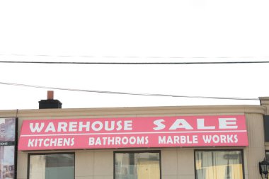 Depo satış mutfakları banyo mermeri mağaza önü yazıları kırmızı arka planda beyaz yazılar ve pencereler.