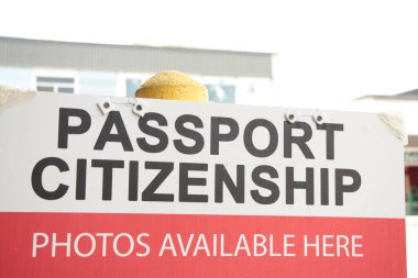 passport citizenship photos available here sign with bright background with building, black white text red white background clipart