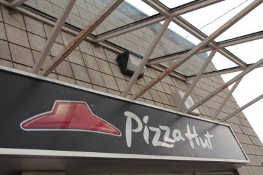 Pizza Hut İşletme Logosu üzerinde cam tepe örtüsü olan pizzacının önünde.