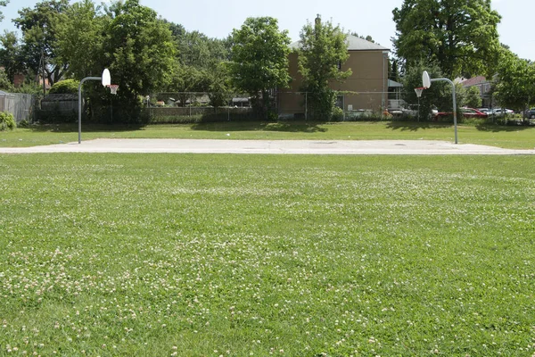 室外公共篮球场被草场包围 场地高耸 全场从侧面射门 — 图库照片
