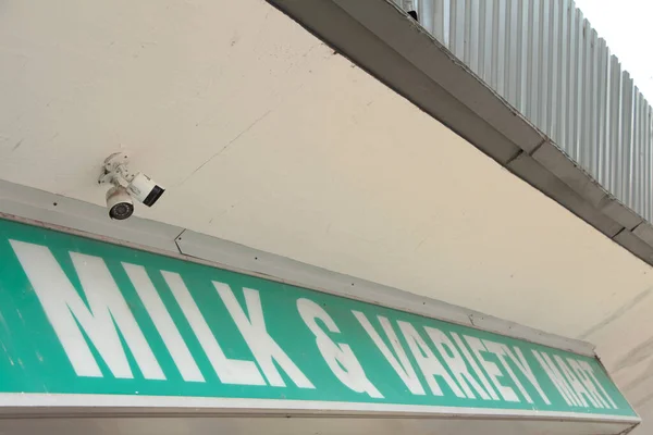 ミルクとバラエティマートライティングキャプションテキストストストア 緑の背景に白いキャピタル文字で店頭に水平長方形のサイン — ストック写真