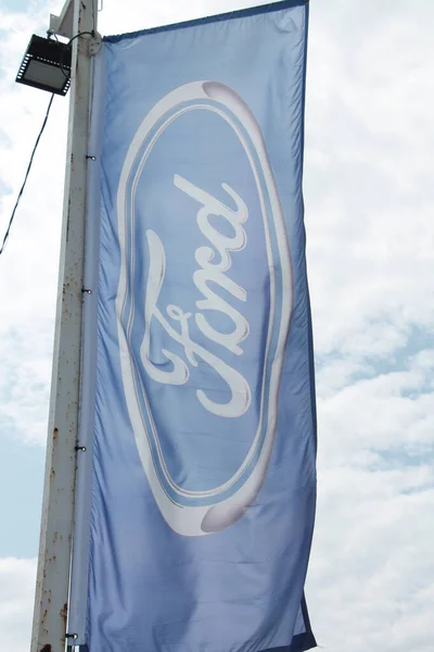 stock image ford motors flag logo blowing in wind with sky in background, portrait