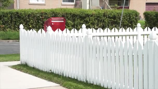 原始的白色警戒线围栏 后面有红色的邮箱和路边灌木丛 — 图库视频影像