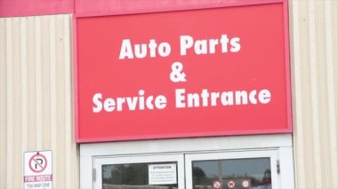 Otomobil parçaları ve servis giriş tabelası sıcak yaz gününde, kırmızı arkaplanda beyaz yazı, kapat